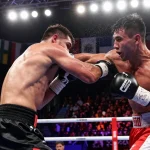 Undisputed champion in an intense championship boxing match delivering a powerful jab with cheering fans.
